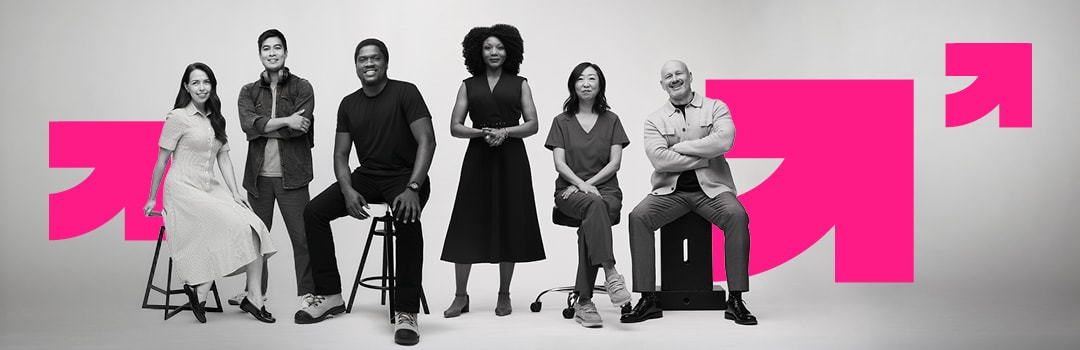 Six Drake people of different ages and backgrounds, seated and standing in a row in front of the pink Drake arrow